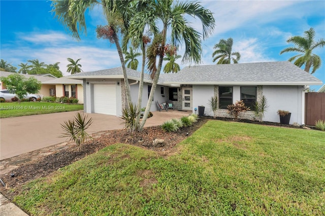 ranch-style home with a garage and a front lawn