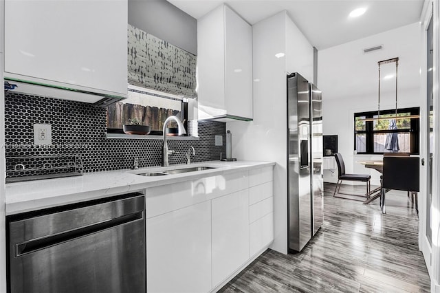 kitchen featuring white cabinets, stainless steel fridge with ice dispenser, sink, and light hardwood / wood-style flooring