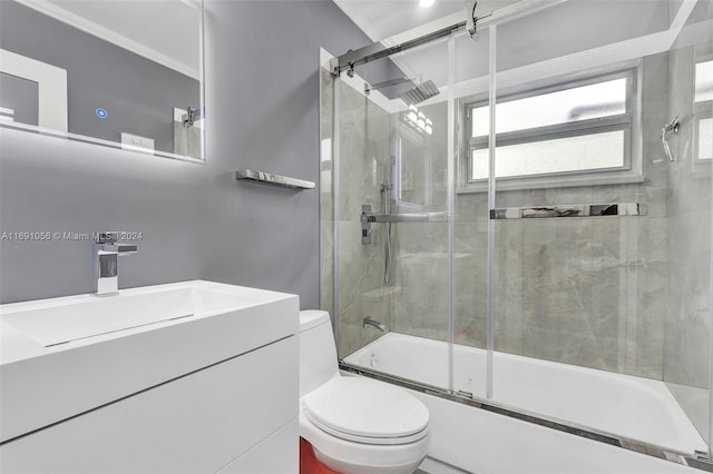 full bathroom featuring toilet, vanity, shower / bath combination with glass door, and ornamental molding