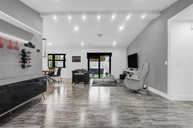 living room with hardwood / wood-style floors, a wealth of natural light, and high vaulted ceiling