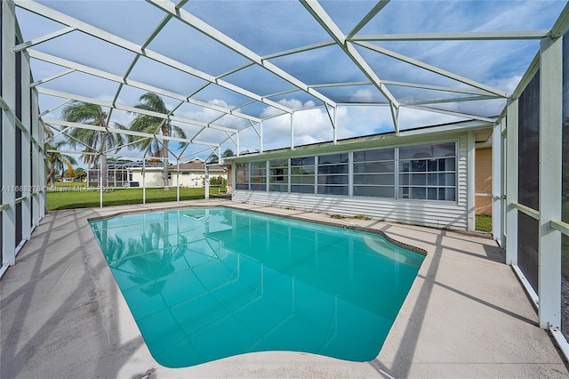 view of pool with a patio and glass enclosure