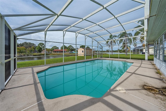 view of swimming pool with a storage shed, a lawn, a water view, glass enclosure, and a patio area