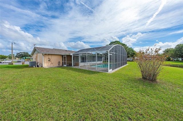 back of house featuring a lanai and a yard