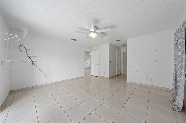 tiled spare room featuring a textured ceiling and ceiling fan