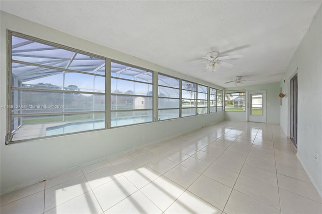 unfurnished sunroom with ceiling fan