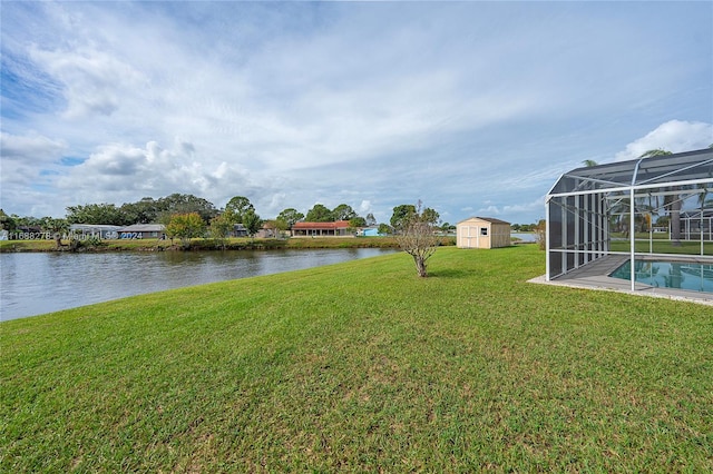 view of yard with a water view, a lanai, and a storage unit