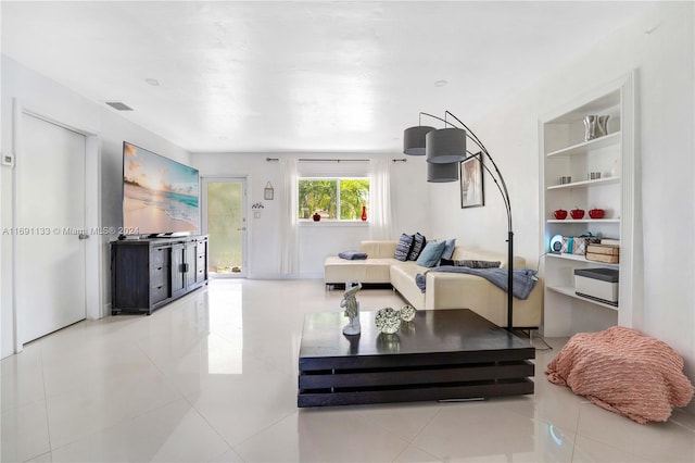 exercise room featuring light tile patterned flooring and built in features