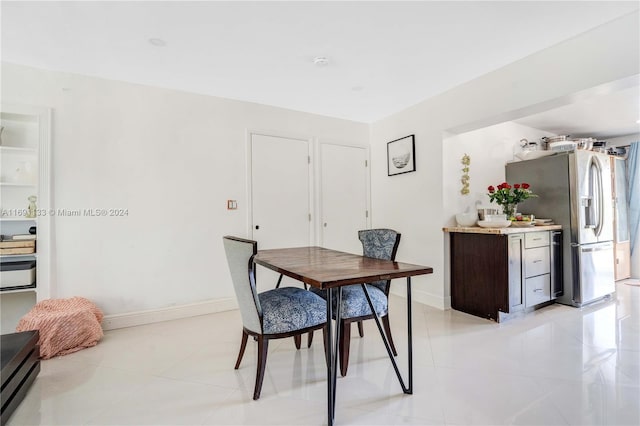 tiled dining area featuring a baseboard heating unit