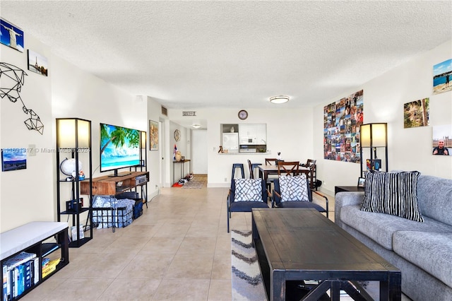 living room with a textured ceiling and light tile patterned floors