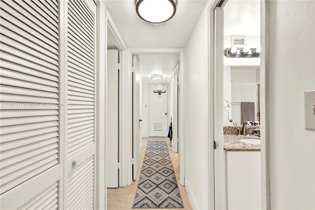 corridor with light tile patterned flooring and sink