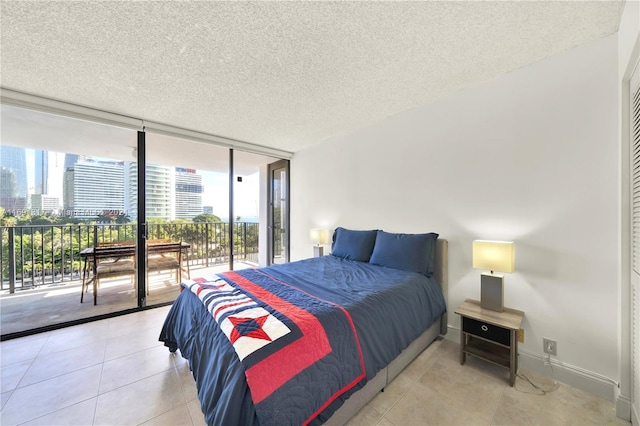 bedroom with expansive windows, access to outside, a textured ceiling, and light tile patterned floors