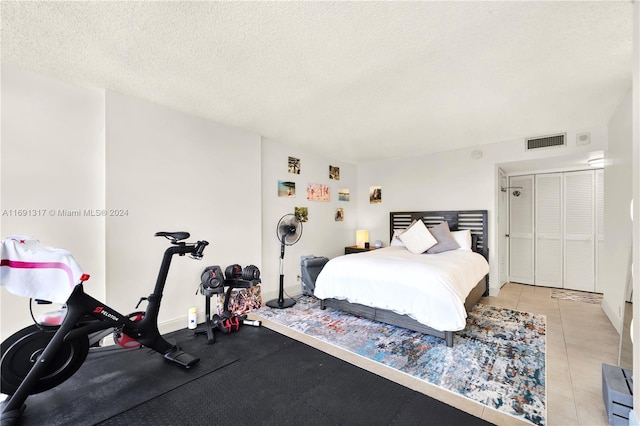 tiled bedroom featuring a textured ceiling