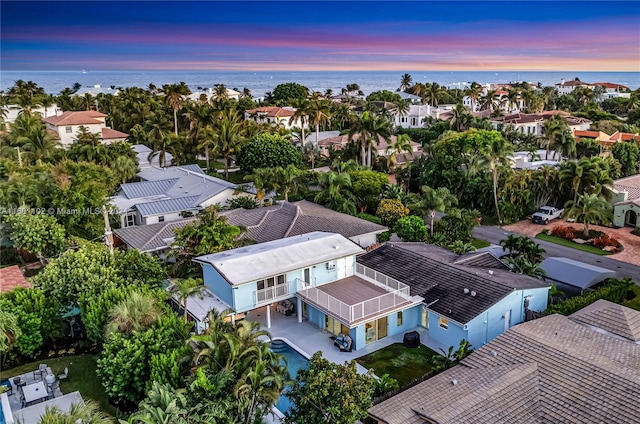 aerial view at dusk featuring a water view