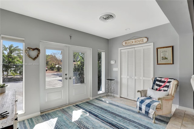 foyer entrance featuring french doors and light tile patterned floors