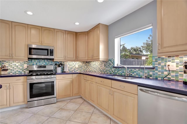 kitchen with sink, light brown cabinets, tasteful backsplash, light tile patterned floors, and appliances with stainless steel finishes