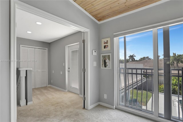 interior space with lofted ceiling, crown molding, wood ceiling, and light carpet