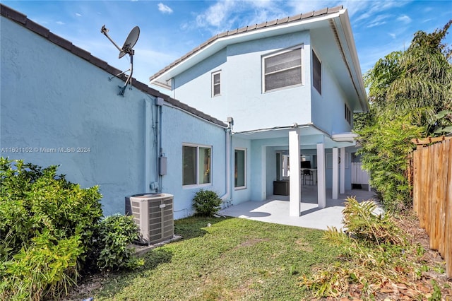 rear view of house featuring central AC, a patio area, and a yard