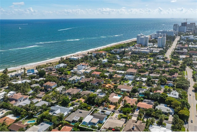 birds eye view of property featuring a water view and a beach view