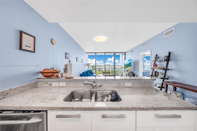 kitchen featuring white cabinetry, sink, light stone counters, and dishwasher