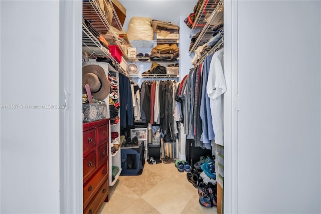 walk in closet with light tile patterned floors