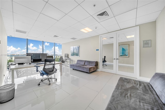 tiled office with a drop ceiling and expansive windows