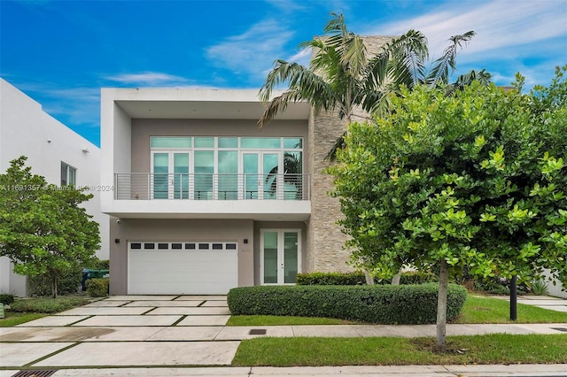 contemporary home featuring a garage and a balcony