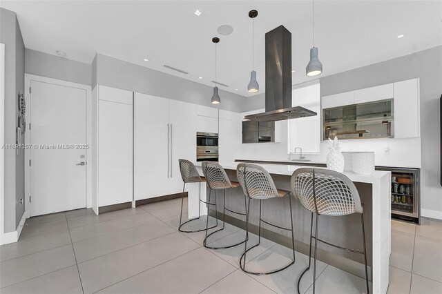 kitchen featuring black electric cooktop, sink, hanging light fixtures, ventilation hood, and beverage cooler