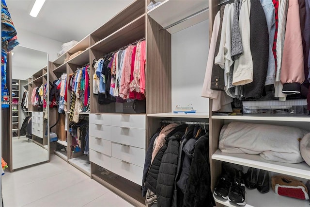 walk in closet with light tile patterned floors