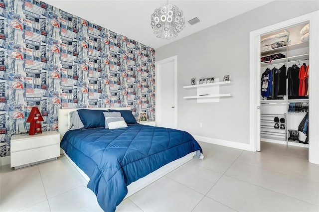 bedroom with a chandelier, tile patterned floors, and a closet