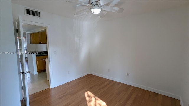 empty room featuring ceiling fan and light hardwood / wood-style flooring