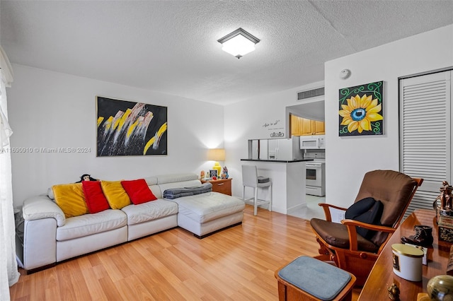 living room with light hardwood / wood-style floors and a textured ceiling