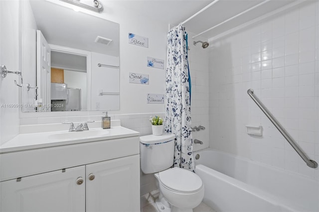 full bathroom featuring vanity, toilet, shower / bath combo with shower curtain, and tile walls