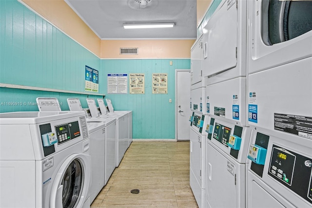 laundry room with washing machine and clothes dryer, stacked washer / dryer, and ornamental molding