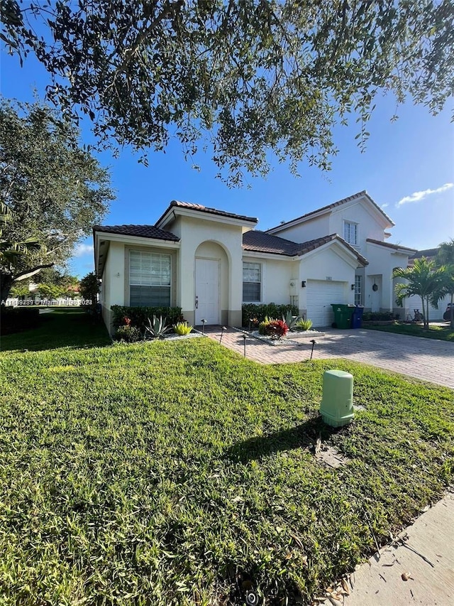 view of front of home featuring a garage and a front lawn