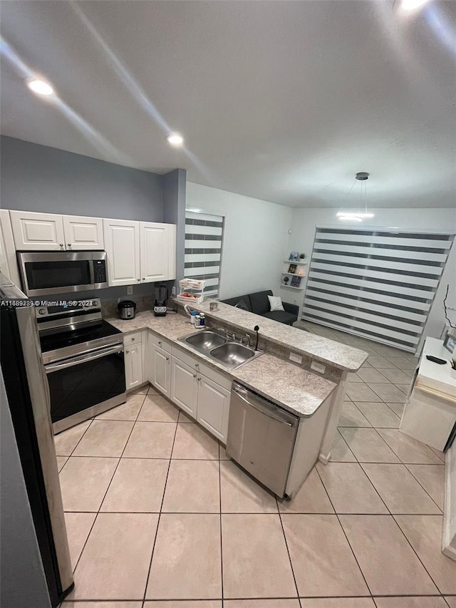 kitchen featuring light tile patterned flooring, stainless steel appliances, sink, white cabinets, and kitchen peninsula