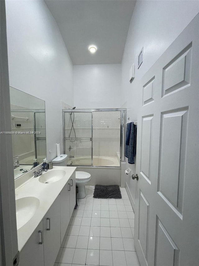 full bathroom with tile patterned floors, vanity, high vaulted ceiling, toilet, and combined bath / shower with glass door