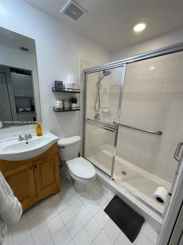 bathroom featuring toilet, an enclosed shower, vanity, and tile patterned floors