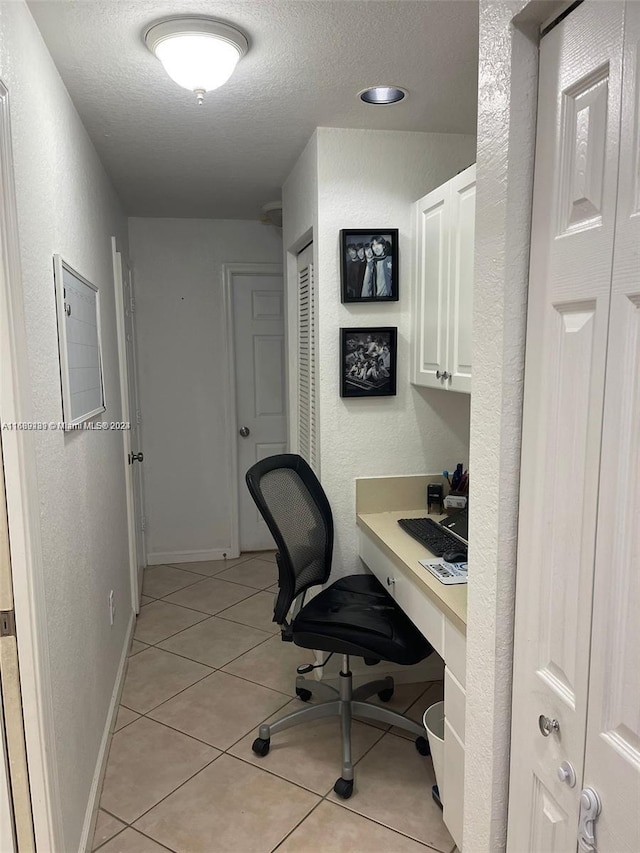 tiled office space with a textured ceiling