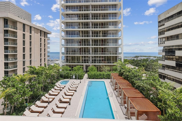 view of pool featuring a patio area and a water view