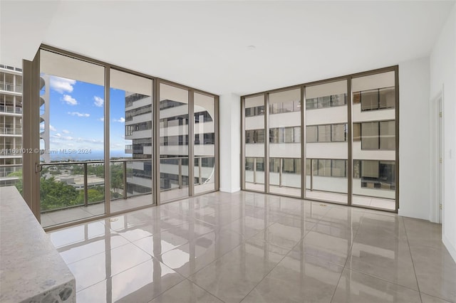 empty room featuring light tile patterned floors and floor to ceiling windows