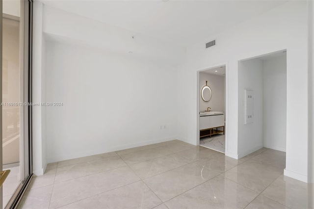 tiled spare room featuring sink