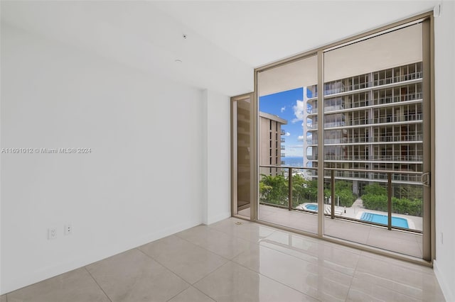 tiled empty room with floor to ceiling windows