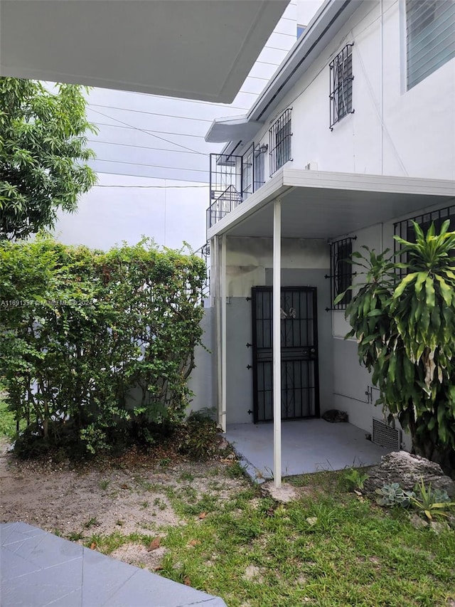 view of exterior entry with a balcony