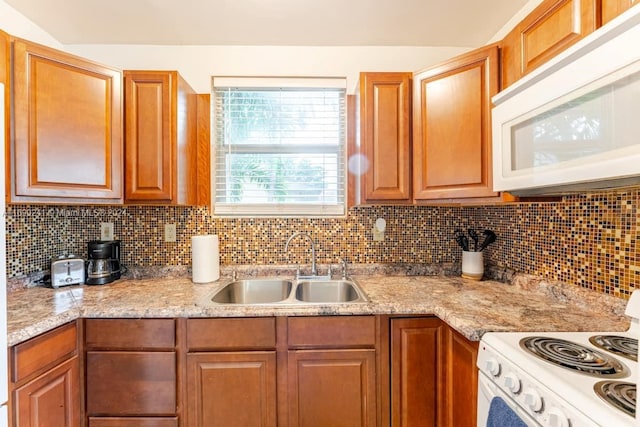 kitchen with backsplash, light stone counters, white appliances, and sink