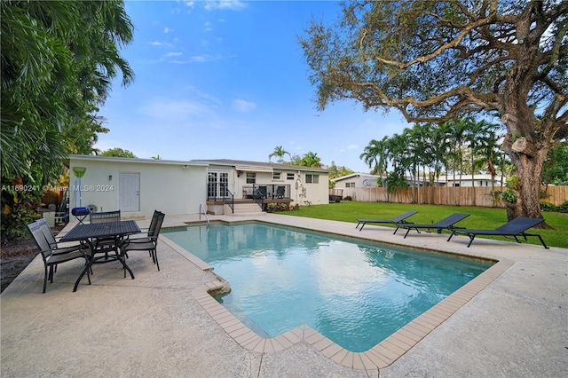 view of pool featuring a lawn and a patio area