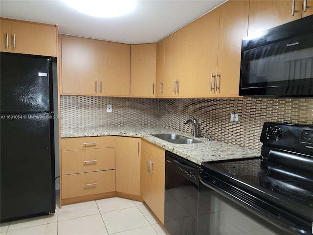 kitchen with backsplash, sink, light tile patterned floors, and black appliances