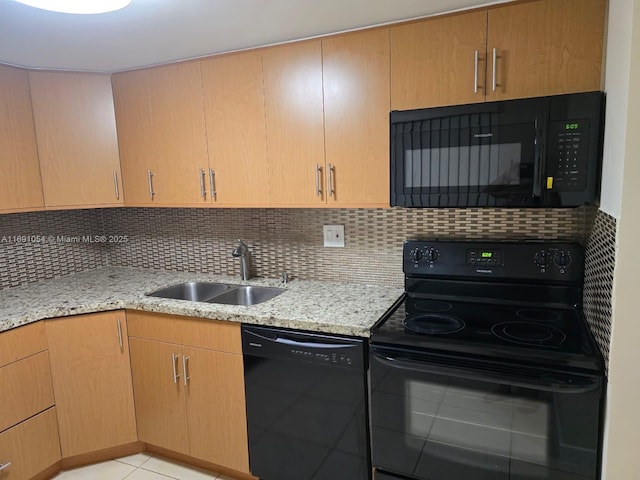 kitchen featuring tasteful backsplash, sink, black appliances, and light stone countertops