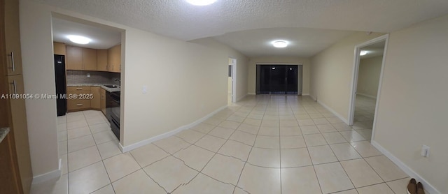 hallway with light tile patterned floors and a textured ceiling