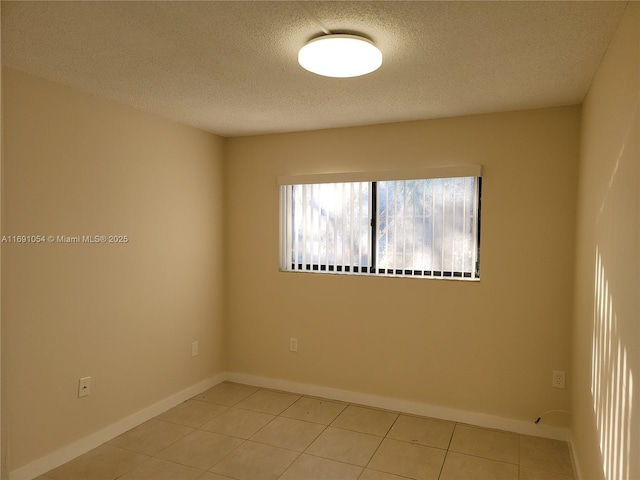 tiled spare room featuring a textured ceiling