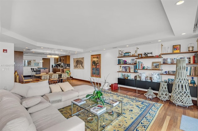 living room featuring hardwood / wood-style floors and a tray ceiling